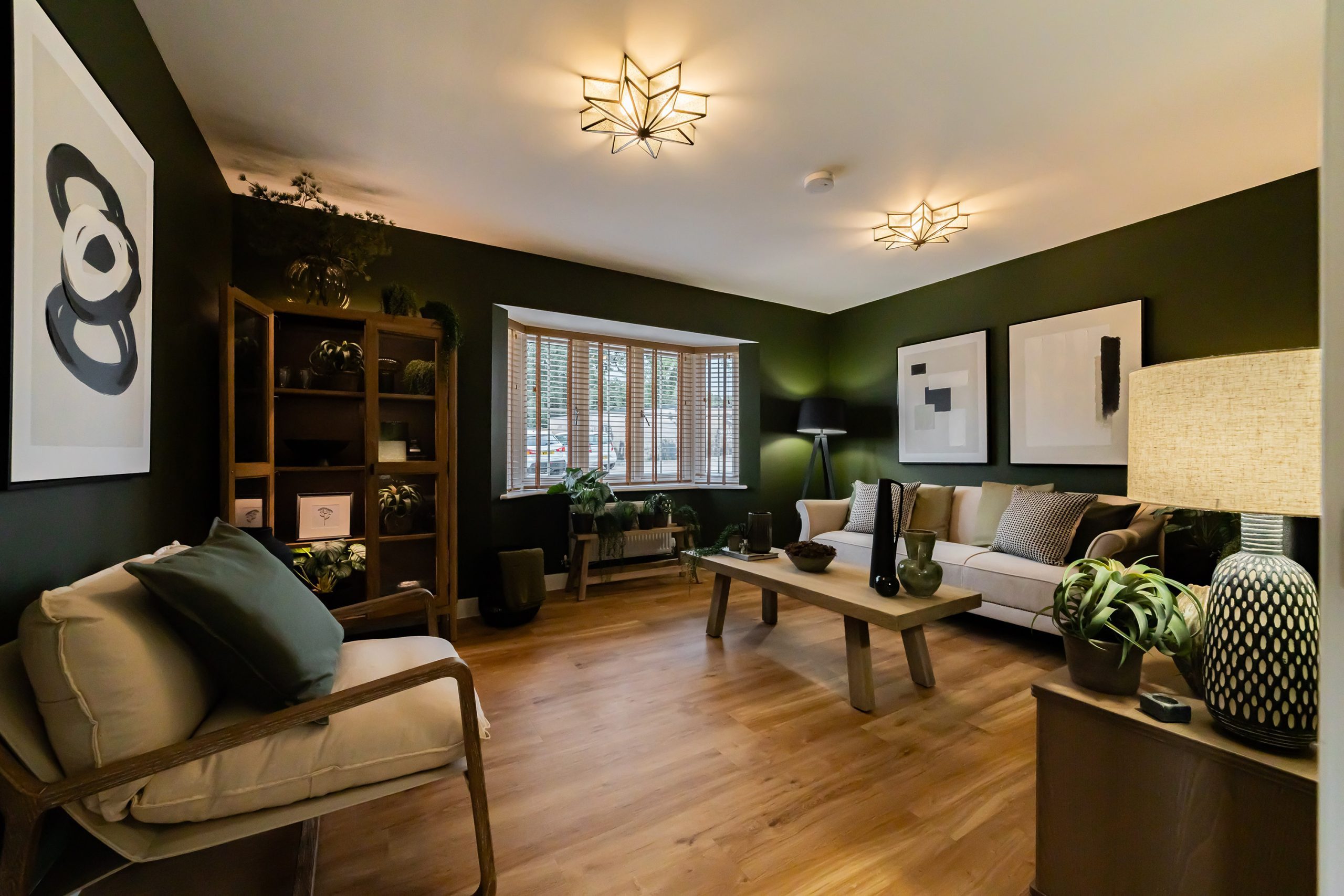 Bright utility room with stainless steel sink, white shaker cabinets, and open wire shelving displaying glass jars and potted plants